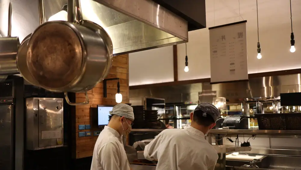 Two chefs working in a professional kitchen, highlighting culinary expertise and teamwork.